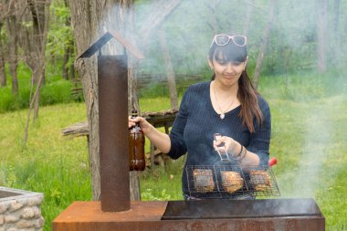 çekici bir kadın üzerinde piknik Barbekü yemek