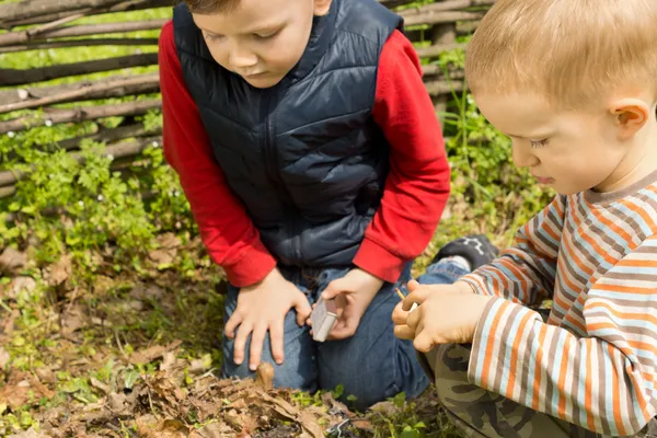 Dos niños pequeños tratando de encender un fuego —  Fotos de Stock