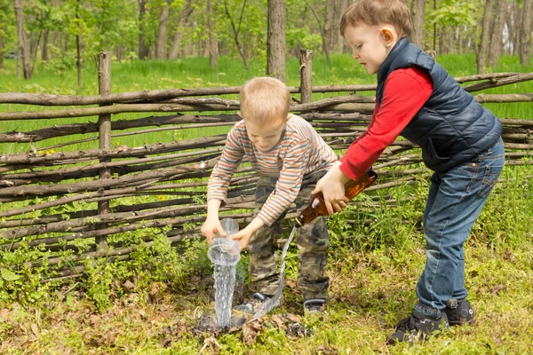 Two young boys putting out a fire — Stock Photo, Image
