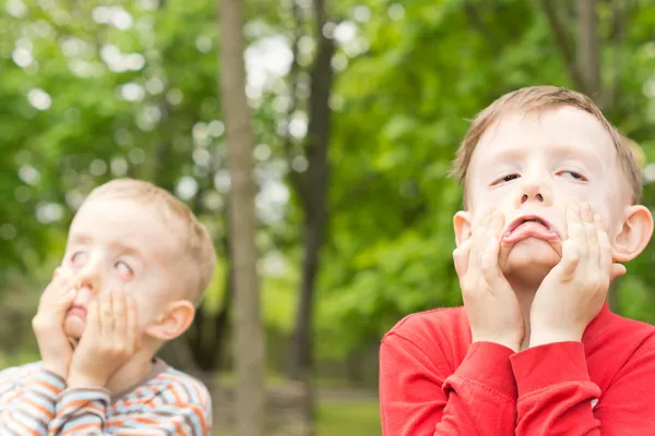 Due giovani ragazzi che tirano facce divertenti — Foto Stock