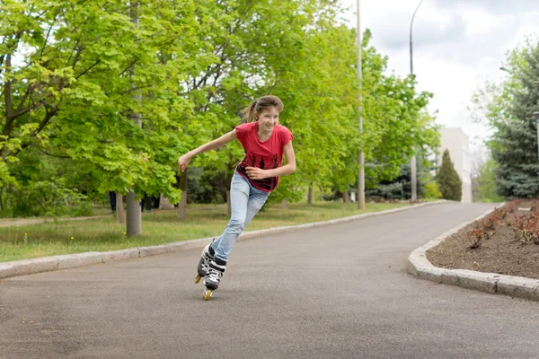 Young teenage girl roller skating around a bend — Stock Photo, Image