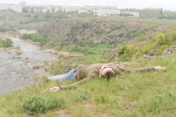 Человек, наслаждающийся солнцем, лежащим на холме — стоковое фото