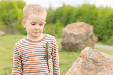 Göğsünde bir kertenkele ile şirin küçük çocuk