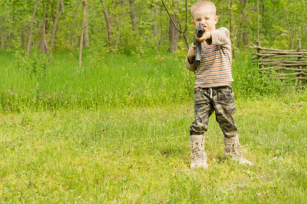 自動小銃を指す小さな男の子 — ストック写真