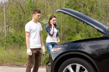 Young couple phoning for roadside assistance