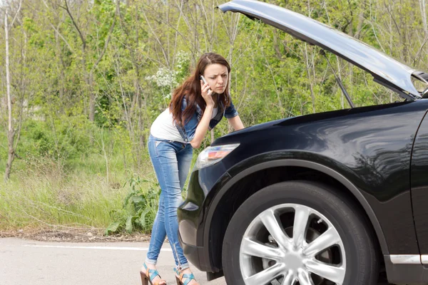 Attractive woman driver calling for assistance — Stock Photo, Image