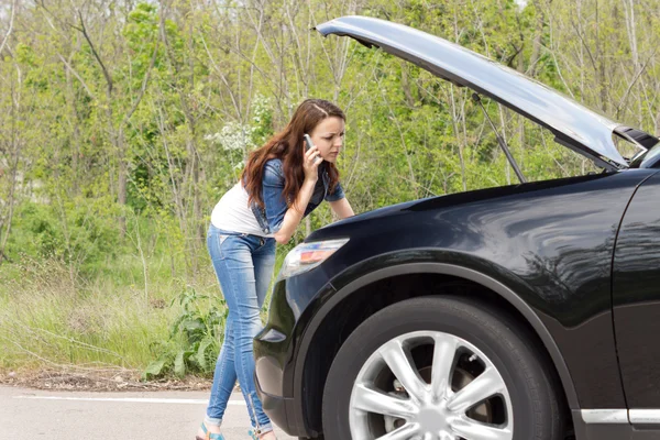 Female driver phoning for help after a breakdown — Stock Photo, Image