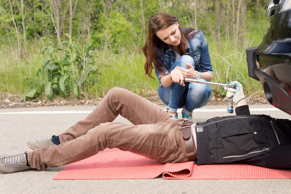 Attractive young woman helping a mechanic — Stock Photo, Image