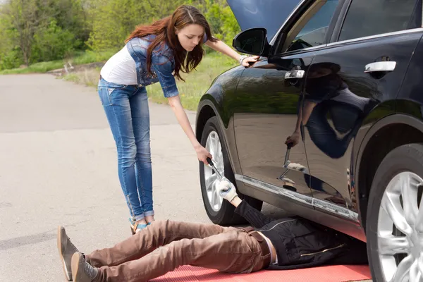 Vrouw stuurprogramma kijken een monteur fix haar auto — Stockfoto