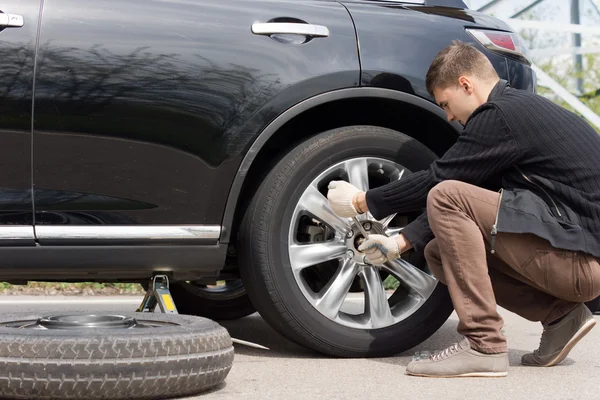 Man changing his spare wheel — Stock Photo, Image