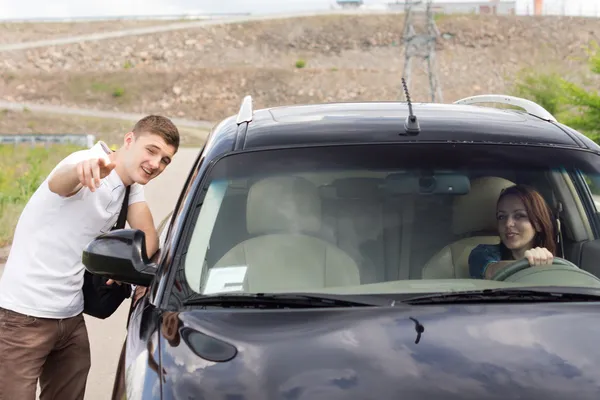 Young man giving directions to a woman driver — Stock Photo, Image