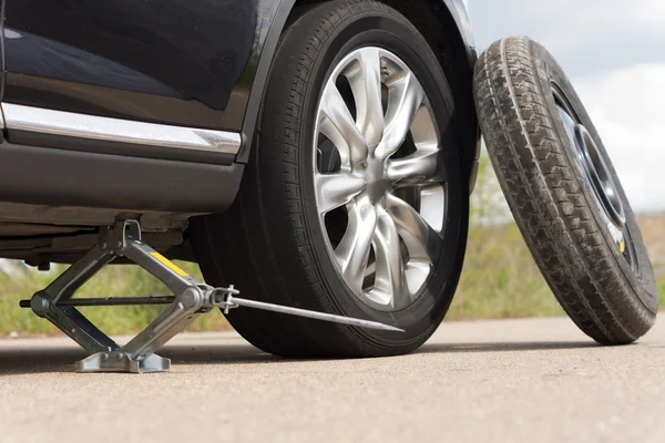 Robar un coche para cambiar un neumático Imágenes De Stock Sin Royalties Gratis