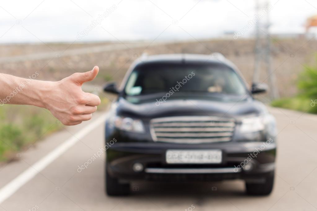 Man thumbing a lift at the roadside