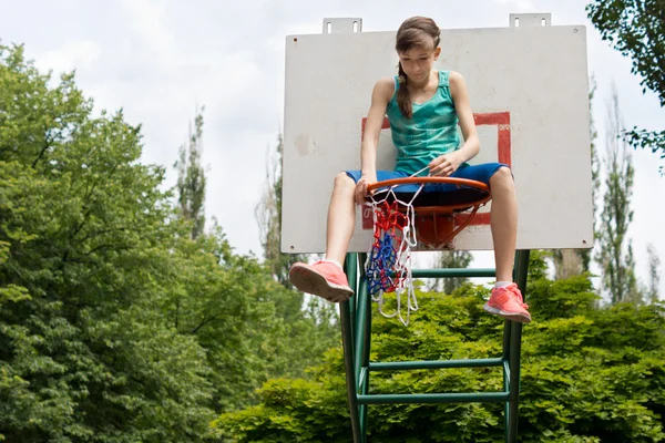 Adolescente consertando uma rede de basquete — Fotografia de Stock