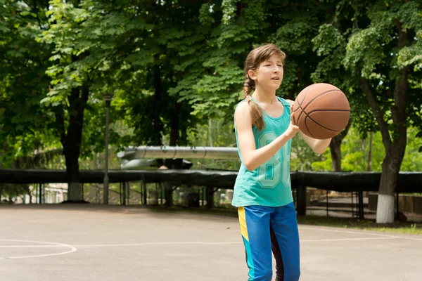 Beautiful teenage girl playing basketball — Stock Photo, Image