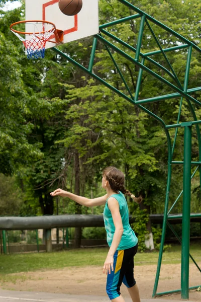 Young teenage girl throwing a basketball — Stock Photo, Image