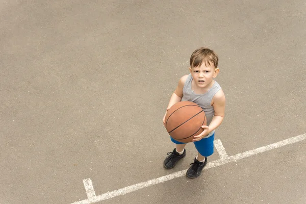 Niño pequeño con un baloncesto mirando perplejo — Foto de Stock