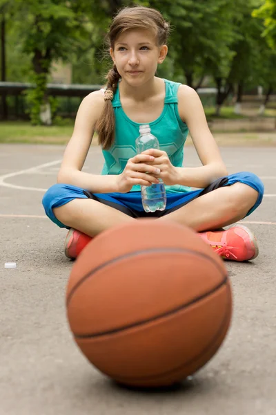 Sportovní dospívající dívka pití balené vody — Stock fotografie