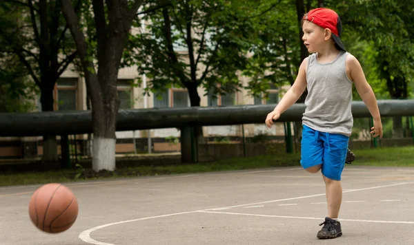 Menino desportivo jogando basquete — Fotografia de Stock