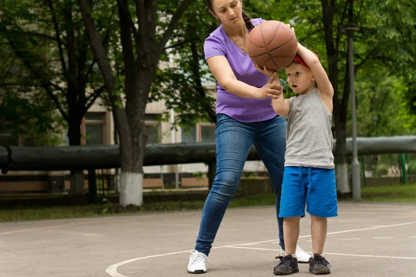 Mãe ensinando seu filho a jogar basquete — Fotografia de Stock