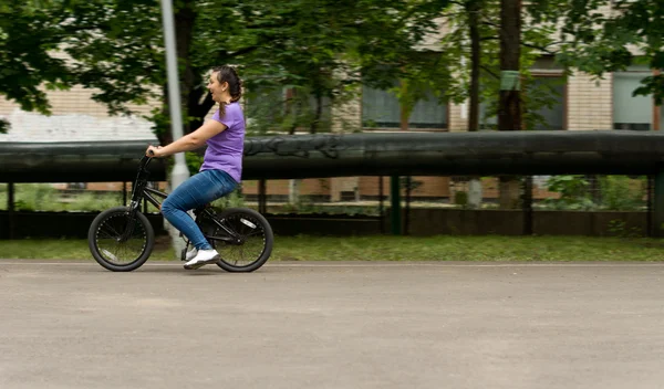 Привлекательная женщина средних лет на детском велосипеде — стоковое фото