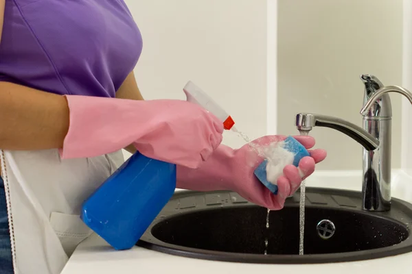 Frau spritzt Waschmittel auf Schwamm — Stockfoto
