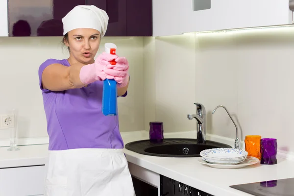 Housewife having fun taking aim with the detergent — Stock Photo, Image