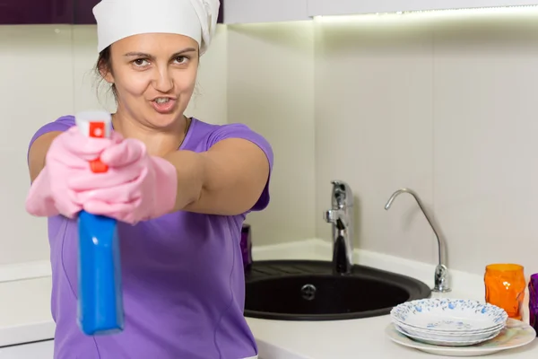 Dona de casa brincalhão apontando o frasco de spray — Fotografia de Stock