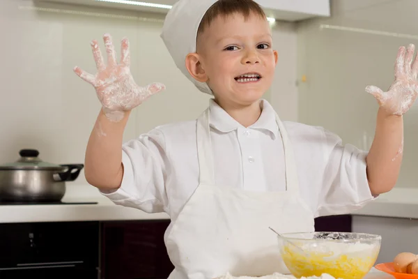 Feliz chico horneando mostrando sus manos harinosas — Foto de Stock