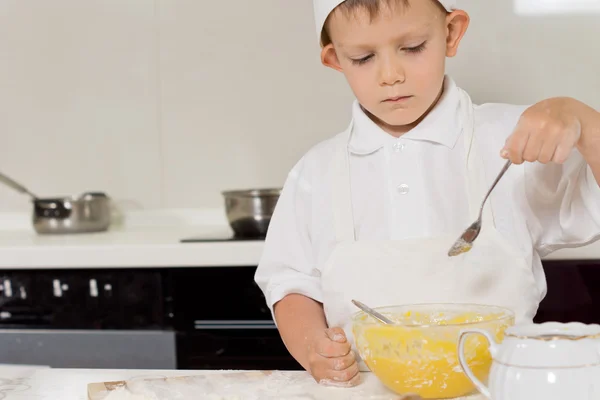 Mały kucharz sprawdzania spójności jego ciasto — Zdjęcie stockowe