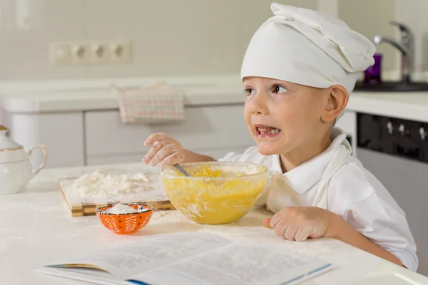 Piccolo ragazzo cuocere la sua torta preferita — Foto Stock