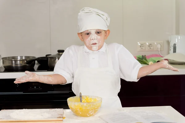 Jovem cozinheiro com um rosto cheio de farinha encolhendo os ombros — Fotografia de Stock