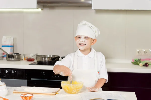 Счастливый симпатичный мальчик, пекущий на кухне — стоковое фото