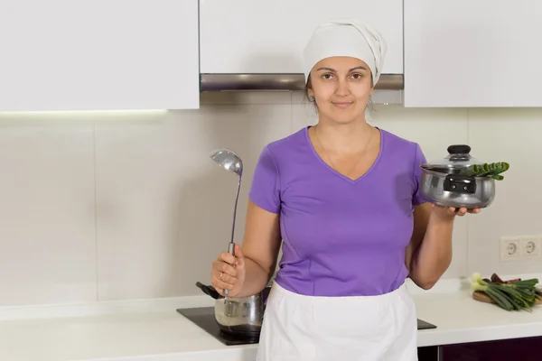Mujer sosteniendo cucharón y olla en la cocina —  Fotos de Stock