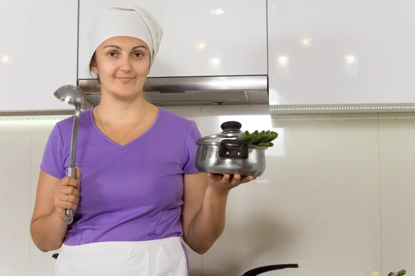 Housewife standing showing pot — Stock Photo, Image
