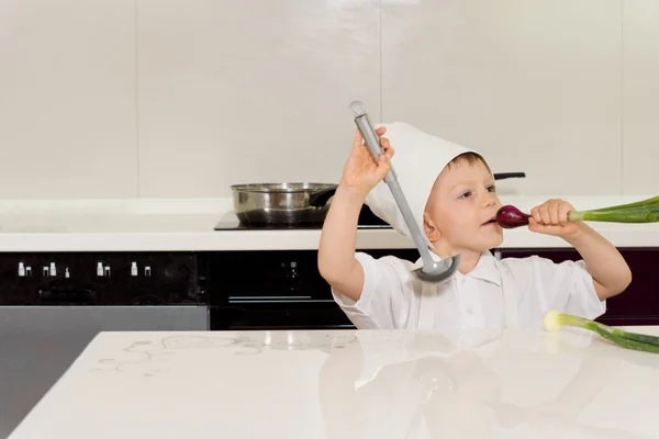 Als Koch verkleideter kleiner Junge spielt — Stockfoto