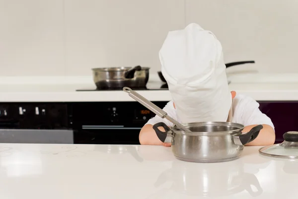 Chef cansado deitado de cabeça para baixo na mesa — Fotografia de Stock