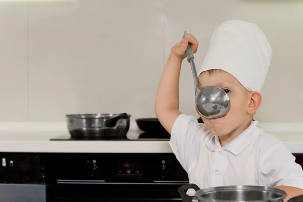 Young chef tasting soup from ladle — Stock Photo, Image