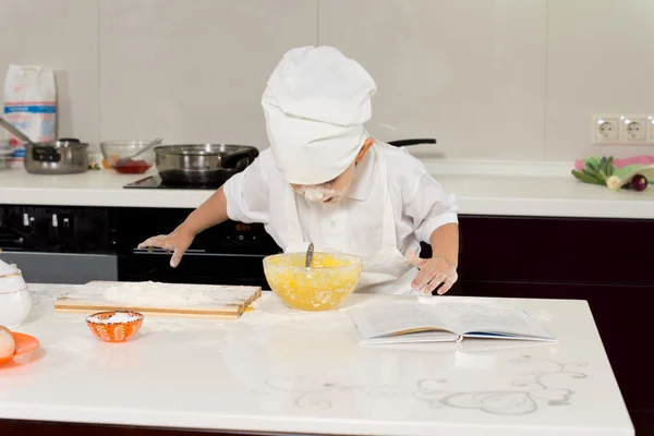 Excited young chef leaning over mixing bowl — Stock Photo, Image