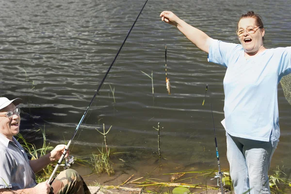 Laughing couple displaying their tiny fish — Stock Photo, Image