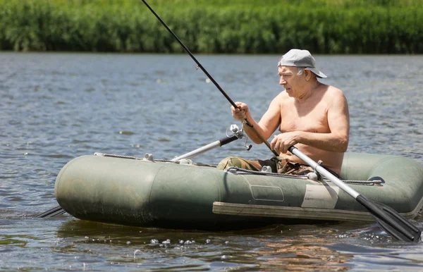 Pêcheur âgé s'arrêtant pour vérifier sa ligne — Photo