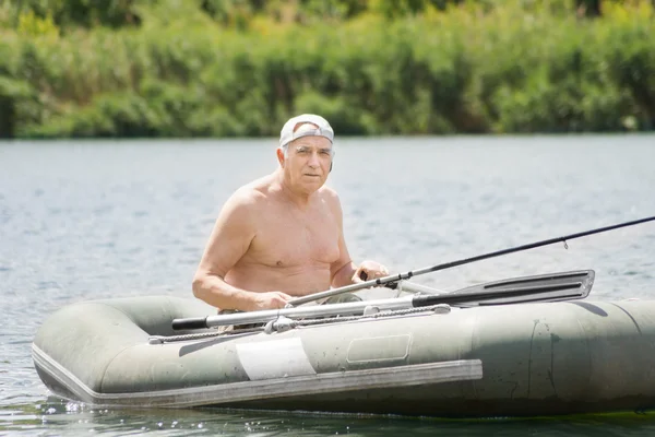 Pêcheur senior souriant profitant d'une journée sur un lac — Photo