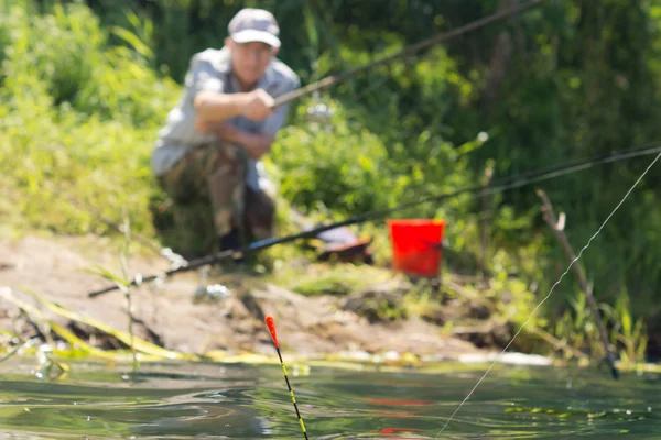 Hombre pescando en el borde de un lago — Foto de Stock