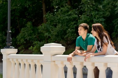 Young couple enjoying the view from a bridge clipart