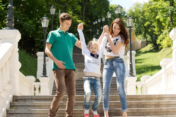 Junges Paar spielt mit einem süßen kleinen Mädchen — Stockfoto