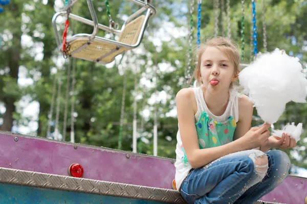 Girl making faces while eating cotton candy — Stock Photo, Image