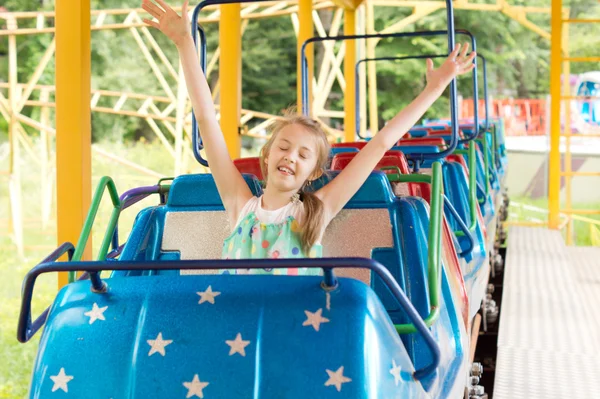 Kleines Mädchen genießt eine Fahrt in einer Achterbahn — Stockfoto