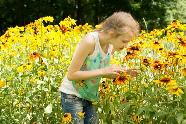 Menina bonita brincando em um jardim colorido — Fotografia de Stock