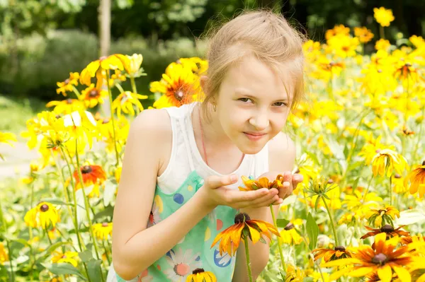 Hübsches kleines Mädchen, das eine gelbe Sommerblume riecht — Stockfoto