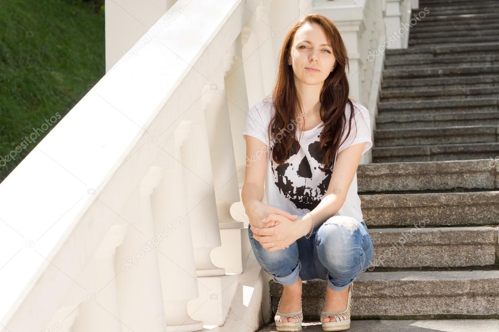 Attractive young woman sitting on steps